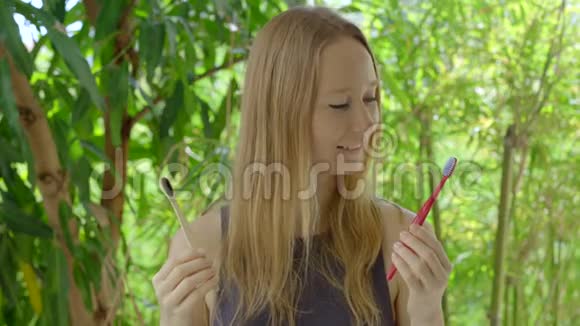 一个年轻的女人选择哪种牙刷来取用竹子或塑料制成的木制牙刷她选择了木制的视频的预览图