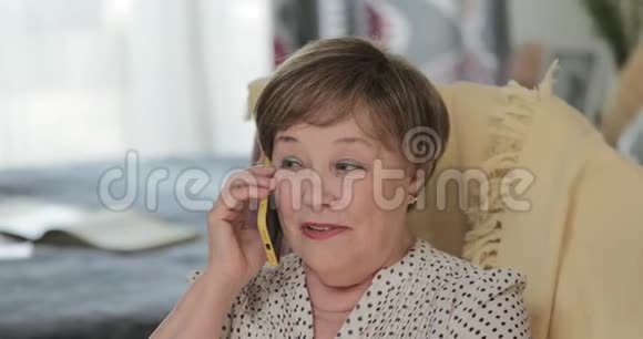 侧面看幸福好看成熟的女人在手机上说话和微笑60岁的老年退休女士视频的预览图