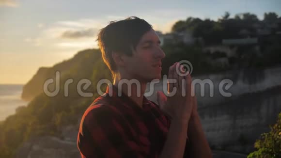 一个人向上帝祈祷的肖像在金色的夕阳上在美丽的风景之上宗教概念视频的预览图