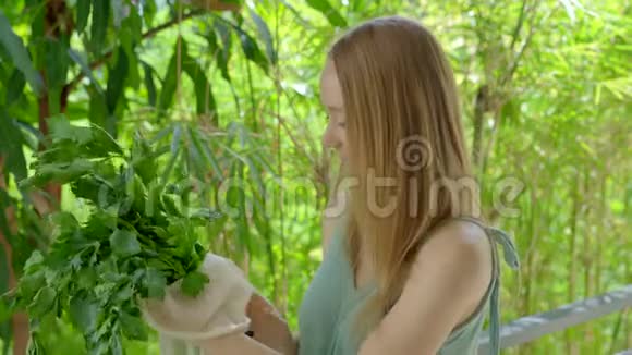 年轻女人把芹菜放进一个可重复使用的袋子里减少塑料污染的概念减少和再利用视频的预览图