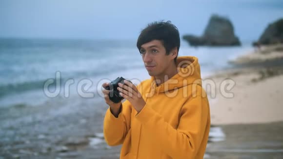 大自然摄影师在美丽的热带海滩拍摄日落时的海浪男性旅行摄影师视频的预览图