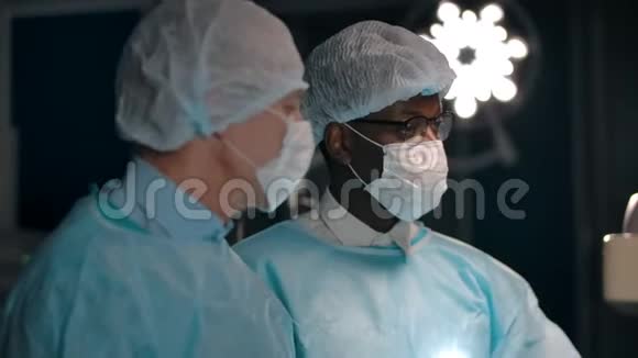 多个种族的外科医生在手术室里说话视频的预览图