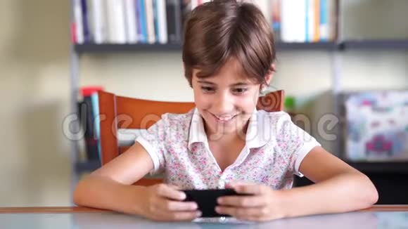 快乐女孩用智能手机玩游戏视频的预览图
