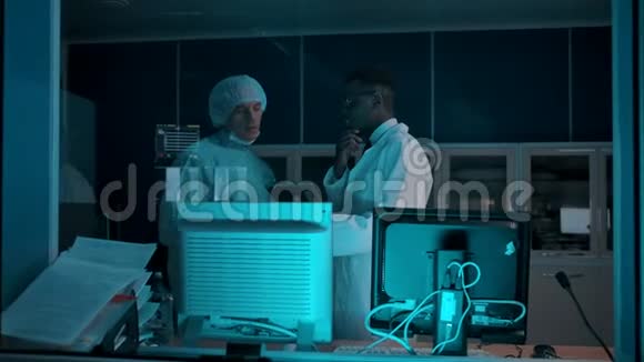 手术室附近的控制室里有两个医生在讨论即将进行的手术视频的预览图