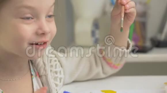左手女孩用水彩颜料和画笔画彩虹孩子们的共同创造力视频的预览图