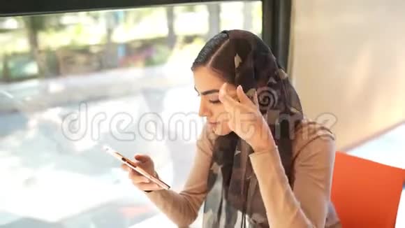 坐在城市台阶上使用智能手机的波斯女人视频的预览图