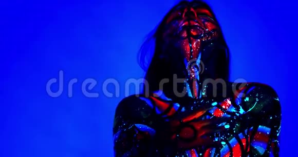 紫外线派对上的一个女人的肖像跳舞和摆姿势身体艺术4k视频的预览图