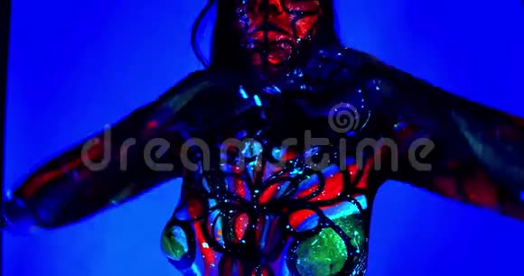 接近一个拥有紫外线发光身体艺术的女人在工作室摆姿势4K视频的预览图