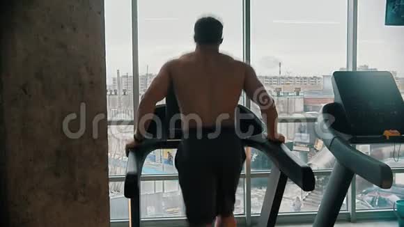 一个在跑步机上跑步的健美男子视频的预览图