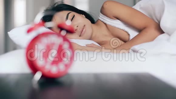 美丽快乐的女孩在床上醒来关掉闹钟然后下床视频的预览图
