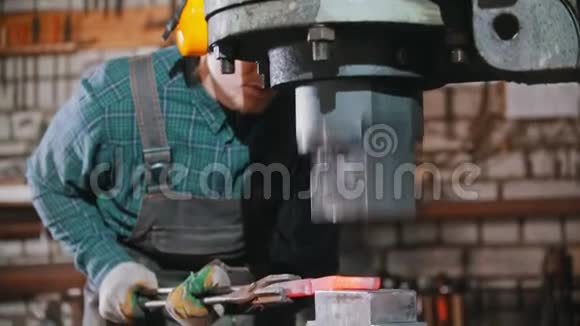 锻造工业一个铁匠把铁块置于大型工业锻造机的压力之下视频的预览图