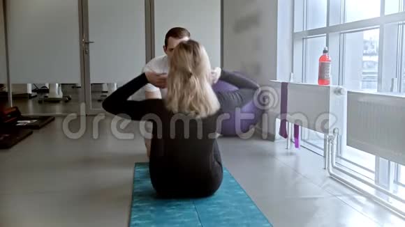 现代白色健身房男人和女人在健身房健身女人抽她的腹肌视频的预览图