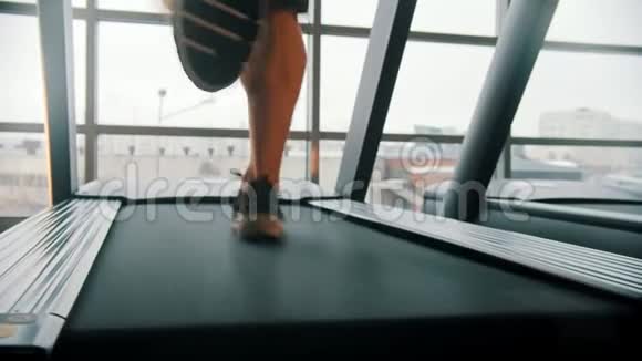 一个人在大窗户前的跑步机上跑步视频的预览图