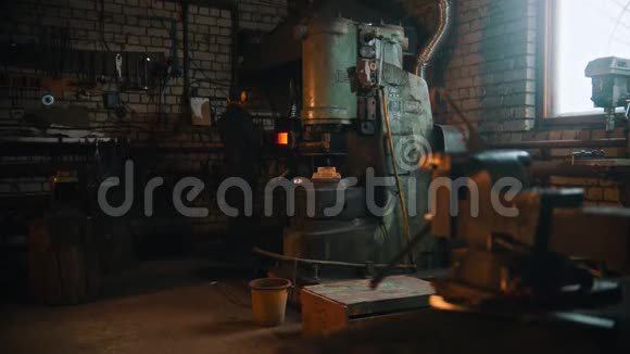 锻造工业一个在车间里用大压力机器工作的铁匠视频的预览图