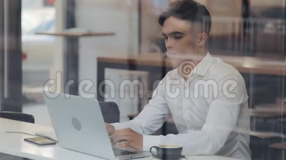 年轻有魅力的商人靠在笔记本电脑上完成办公室工作工作完成后感到轻松他在伸展视频的预览图