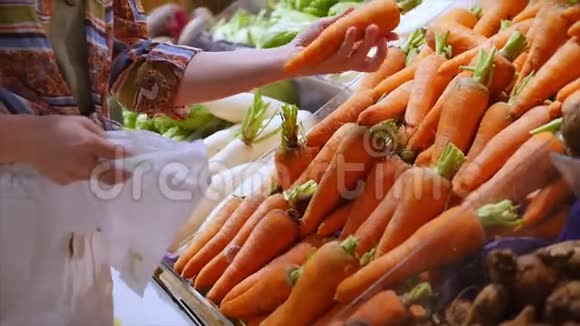 漂亮的年轻漂亮的女孩或女人在市场上买食物在市场上摘胡萝卜卷心菜生菜花椰菜视频的预览图