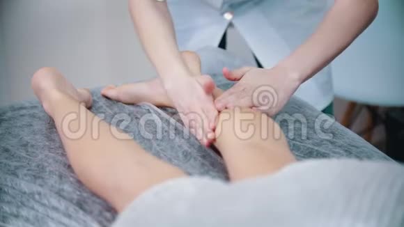 按摩按摩治疗师正在揉她的客户的腿视频的预览图