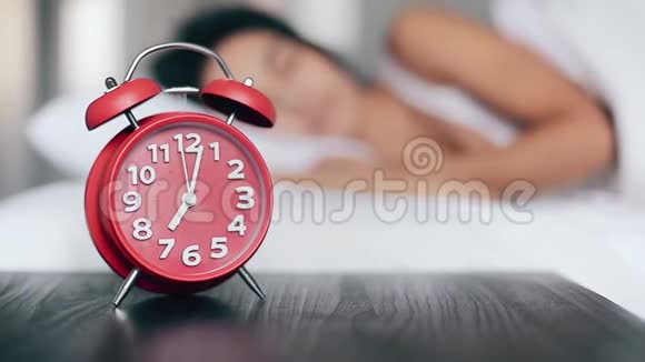 美丽的女孩睡在床上关掉闹钟继续睡觉关注闹钟视频的预览图