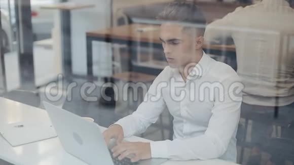 快乐的年轻商人在舒适的咖啡店里用笔记本电脑喝咖啡视频的预览图