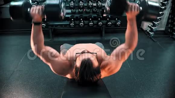 一个戴眼镜的健美运动员在健身房的看台上抽着他的手肌肉视频的预览图