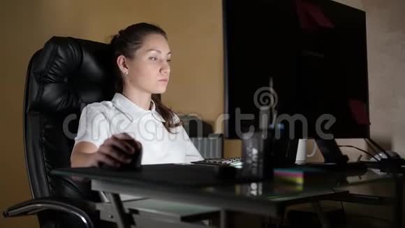 女孩在一张大扶手椅上的电脑上工作喝茶或咖啡视频的预览图