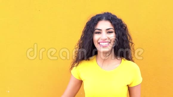 街上黄墙上的年轻阿拉伯休闲女子笑着笑着视频的预览图