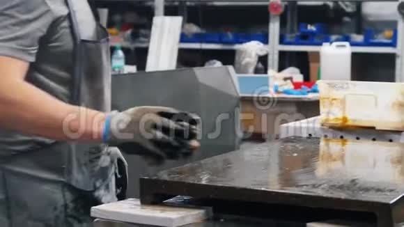 混凝土车间一名男子用特殊溶液擦拭车间表面视频的预览图