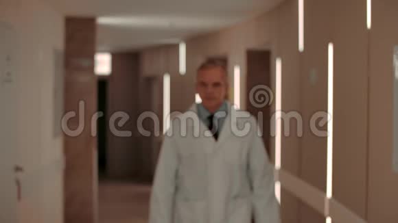 自信的中年医生在医院走廊散步视频的预览图