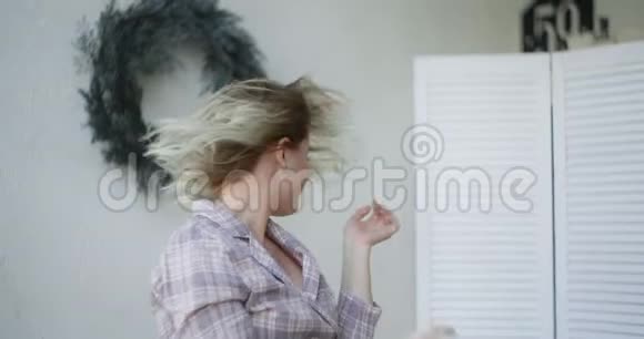 在皮贾马的年轻性感女人转过头缓慢地摇着头发卷曲的欧洲女人在家里斯堪的纳维亚视频的预览图