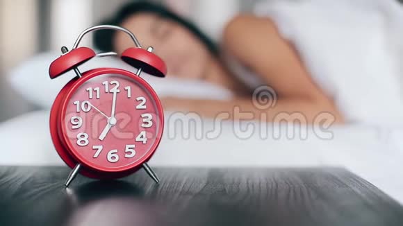 美丽的女孩睡在床上关掉闹钟继续睡觉关注闹钟视频的预览图