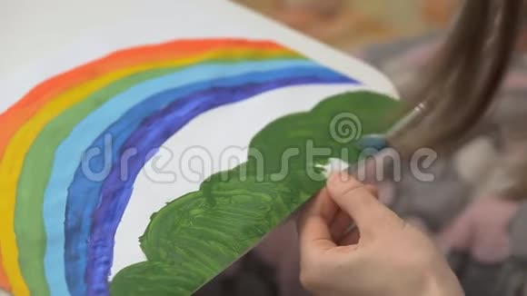 女生用水彩颜料和画笔画出彩虹幼儿共同创意视频的预览图