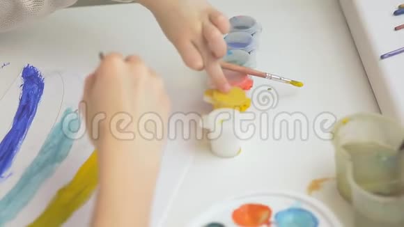 两个女孩用水彩和画笔画出彩虹孩子们共同的创造力视频的预览图