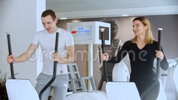 现代健身房运动员和女运动员在健身房做早操大笑视频的预览图