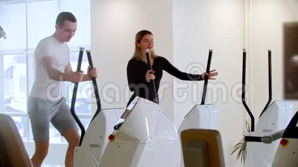 现代健身房一个男人和一个女人在健身房做早操笑着视频的预览图