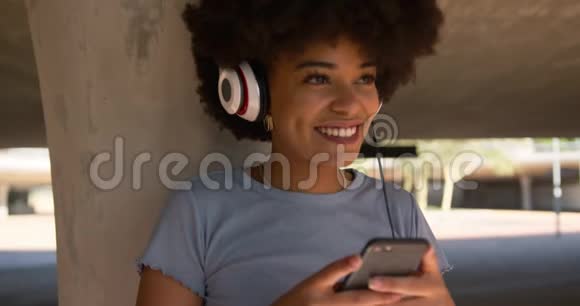 混血女人在桥下听音乐视频的预览图