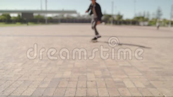 一个微笑的年轻男性滑板运动员骑在滑板上朝镜头的城市街道的肖像视频的预览图