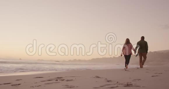 活跃的高级夫妇在海滩上散步视频的预览图