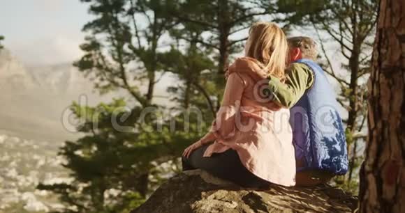 活跃的老夫妇坐在森林的岩石上视频的预览图