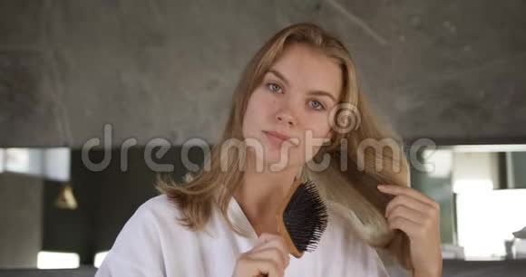 酒店内白种人妇女梳头的正面景色视频的预览图