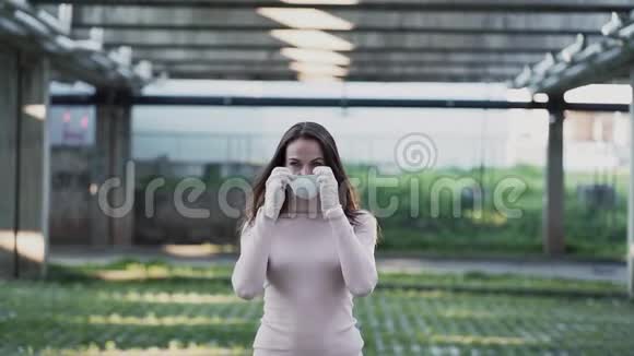 一个戴着医用防护面罩和手套的女孩去拍照视频的预览图