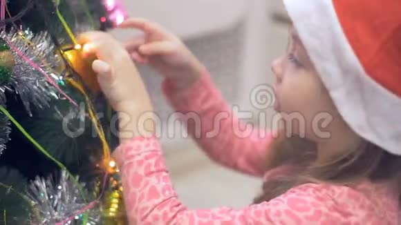 圣诞树附近的小女孩在考虑圣诞玩具视频的预览图