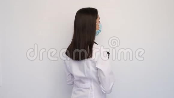 友好的女医生穿着白色医用外套手套和防护面罩拿着客户证视频的预览图