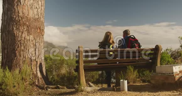 活跃的老夫妇坐在森林的长凳上视频的预览图
