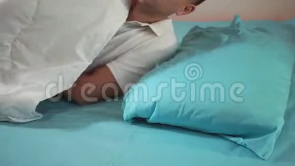 上床睡觉盖着毯子一个年轻人特写晚安睡个好觉视频的预览图