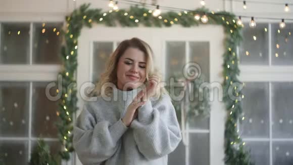 穿暖和衣服的欧洲迷人女人穿着毛衣看着镜头斯堪的纳维亚冬季的内部视频的预览图
