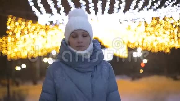 女游客在花环背景下的冬季公园散步视频的预览图