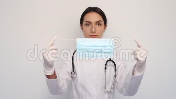 戴白色医疗手套和白色外套的女医生戴防护面罩防止冠状病毒视频的预览图