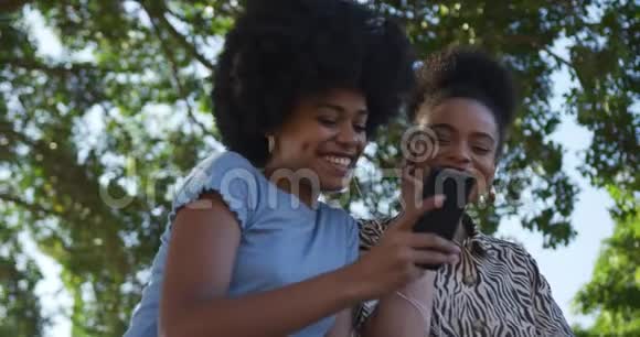 两个混血女人在公园里听音乐视频的预览图