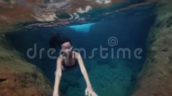 水下射击一名年轻女子在一个干净的自然游泳池水下游泳视频的预览图