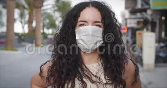 一个年轻的学生混合种族妇女穿着保护要求在街上的肖像健康和安全生活概念视频的预览图